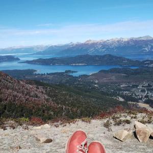 a personas pies en la cima de una montaña con vistas a un lago en 4 Vientos, en Villa La Angostura