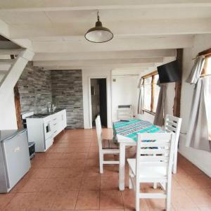 Una cocina y un comedor con mesa y sillas. en 4 Vientos, en Villa La Angostura