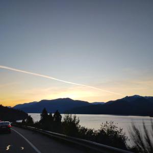 un coche conduciendo por una carretera junto a un lago en 4 Vientos, en Villa La Angostura 4 fotos más