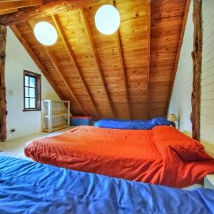 una cama en una habitación con techo de madera en 4 Vientos, en Villa La Angostura