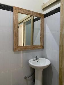 a bathroom with a sink and a mirror at Comeon Amed in Amed