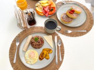 una mesa con platos de desayuno y una taza de café en Natüra Hotel Monteverde en Monteverde