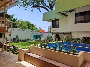 un patio trasero con piscina y una casa en Casa Janaab Palenque en Palenque
