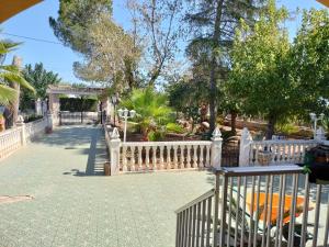 una valla blanca junto a un patio con árboles en Villa les palmiers, en Rafelguaraf