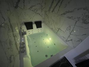 bagno con vasca e parete in marmo di Le cocon Balnéo a Sens