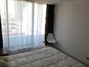 a bedroom with a bed and a large window at APARTAMENT IN PENINSULA IQUIQUE(NEAR OF ALL) in Iquique