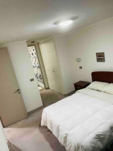 1 dormitorio con 1 cama blanca grande en una habitación en APARTAMENT IN PENINSULA IQUIQUE(NEAR OF ALL) en Iquique