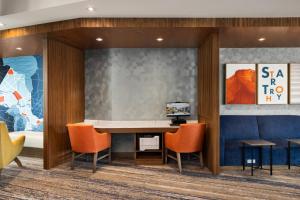 uma sala de espera com uma mesa e cadeiras laranja em Holiday Inn Express - Strathroy, an IHG Hotel em Strathroy