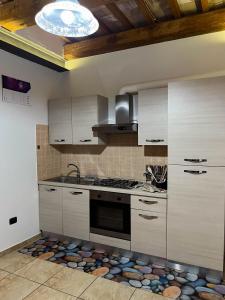 a kitchen with white cabinets and a stove top oven at casa centro storico in Montefiascone