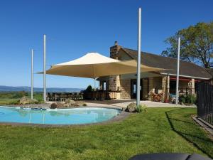 a large tan umbrella in front of a house at Shargmor Stable in Matamata
