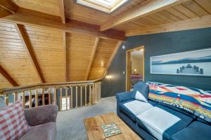 ein Wohnzimmer mit einem blauen Sofa und einer Holzdecke in der Unterkunft Peaceful Cabin Between Flagstaff and Sedona! in Munds Park