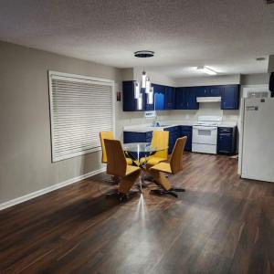 a kitchen with blue cabinets and a table and yellow chairs at Totally Rad Pad! in Midway