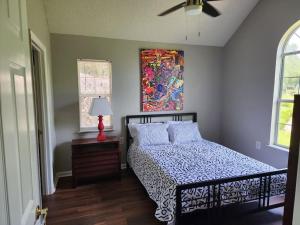 a bedroom with a bed and a painting on the wall at Totally Rad Pad! in Midway