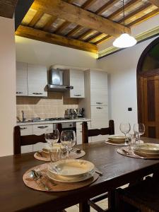 a dining room table with plates and wine glasses at casa centro storico in Montefiascone