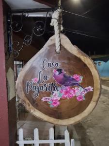 un cartello di legno con un uccello seduto su un ramo di Casa La Pajarita a Santa Marta