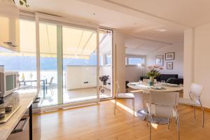 uma cozinha e sala de estar com mesa e cadeiras em Casa Elea_ Panoramic Attic in City Center em Campione dʼItalia