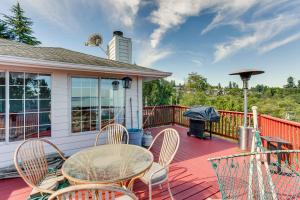 フェデラルウェイにあるFederal Way Vacation Rental Bay and Mountain Views!のデッキにテーブルと椅子が置かれたパティオ