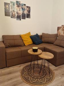 a living room with a brown couch and two tables at Oaza031 in Užice