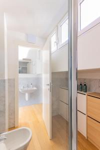 a bathroom with a sink and a toilet in a room at Casa Madlen - Bright Attic with Marvelous View in Campione dʼItalia +14 photos