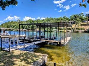 un quai dans l'eau avec un bâtiment dans l'établissement #05 - Lakefront Two Bedroom Cottage- Pet Friendly, à Hot Springs