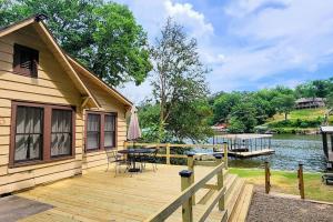 a house with a wooden deck next to a body of water at #05 - Lakefront Two Bedroom Cottage- Pet Friendly in Hot Springs