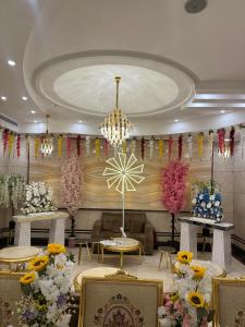 فندق المقام السامي للغرف والشقق المفروشة في مكة المكرمة: غرفة بها زهور على الجدران وثريا