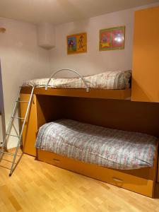 two bunk beds in a room with a bed at Appartamento Ari in Vermiglio