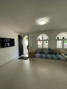 Großes Zimmer mit einem Bett und zwei Fenstern in der Unterkunft Casa em condomínio a 50mt da praia dos ossos in Búzios