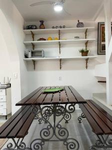 eine Bank in einem Raum mit Regalen in der Unterkunft Casa em condomínio a 50mt da praia dos ossos in Búzios