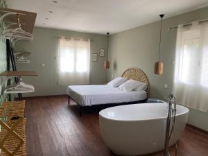 uma casa de banho com banheira e uma cama em Villa Jurio em Argeliers