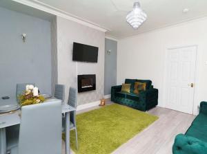 a living room with a green couch and a green rug at The Victoria - Close to Centre - Sleeps 8 in Leeds