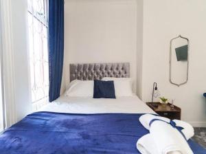 a bedroom with a large bed with a blue blanket at The Victoria - Close to Centre - Sleeps 8 in Leeds