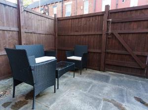 a patio with two chairs and a fence at The Victoria - Close to Centre - Sleeps 8 in Leeds