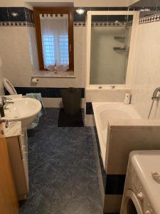 a bathroom with a tub and a sink and a bath tub at Appartamento Ari in Vermiglio