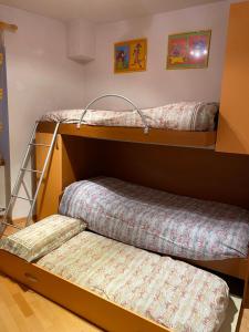 two bunk beds in a room with a ladder at Appartamento Ari in Vermiglio