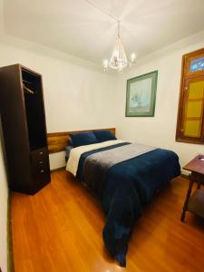 1 dormitorio con 1 cama y vestidor en Maktub Montt - Hostal Boutique en Santiago