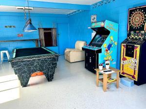 a play room with a pinball machine and a table at Magnolia Village Caravan Park in Hervey Bay