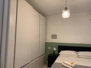 1 dormitorio con 1 cama y luz colgante en "CITY CENTER 10Stars"- Casetta Matteotti- Feel like HOME, en Civitavecchia