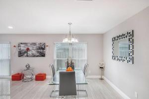 a dining room with a glass table and chairs at Y&M TAMPA SWEET HOME! in Tampa