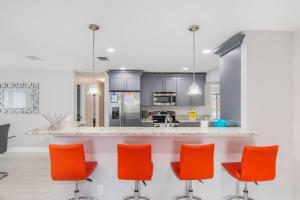 una cocina con sillas naranjas y una barra en Y&M TAMPA SWEET HOME! en Tampa