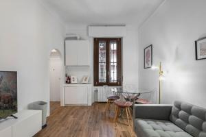 - un salon avec un canapé et une table dans l'établissement Easylife - Coccole e relax nel cuore di Isola, à Milan