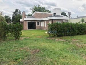 a large house with a grass yard with a house at Sans Souci in Gualeguaychú