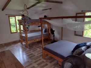 a bedroom with a bunk bed and a couch at Sexto Sentido Cabañas & Pan Frances in Palomino