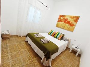 1 dormitorio con 1 cama con una pintura en la pared en Casa Tejera, en Las Palmas de Gran Canaria