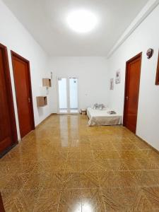 Habitación grande con paredes blancas y suelo de madera. en Casa Tejera, en Las Palmas de Gran Canaria