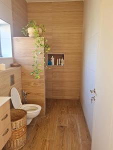 a bathroom with a toilet and a wooden floor at פינה קסומה בגליל in Dafna