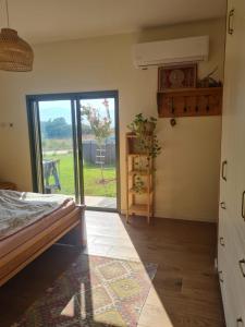 Schlafzimmer mit einem Bett und einer Glasschiebetür in der Unterkunft פינה קסומה בגליל in Kibbuz Dafna
