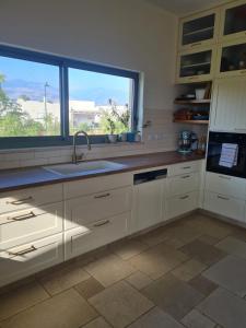 eine Küche mit einem Waschbecken und einem großen Fenster in der Unterkunft פינה קסומה בגליל in Kibbuz Dafna