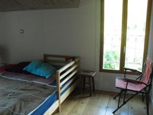 博姆雷達姆的住宿－la quatorze，一间卧室配有一张床、一把椅子和窗户。