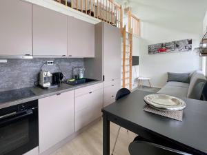 una cocina con armarios blancos y una mesa en una habitación en Stavanger Bnb at nicolas 11, en Stavanger